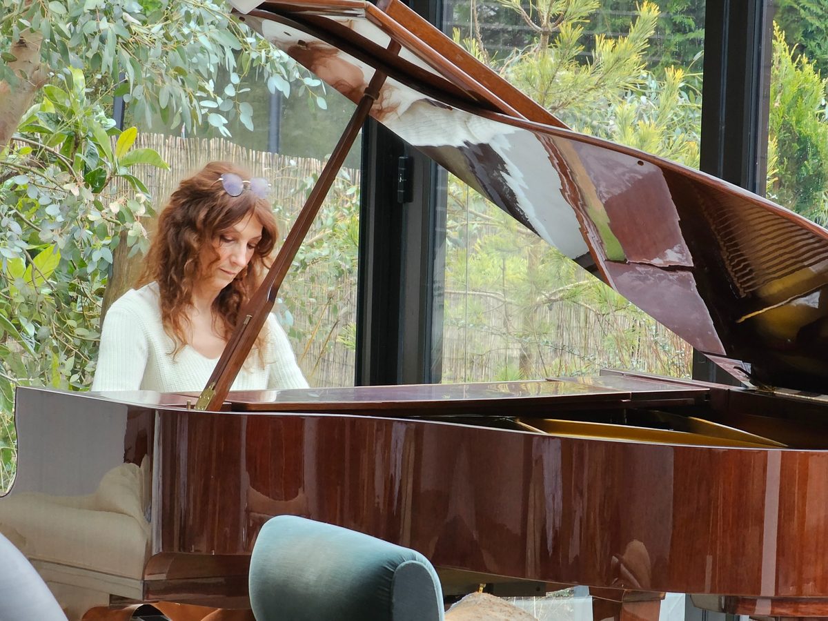 Yolande Ballot, professeure de piano, jouant sur un piano à queue